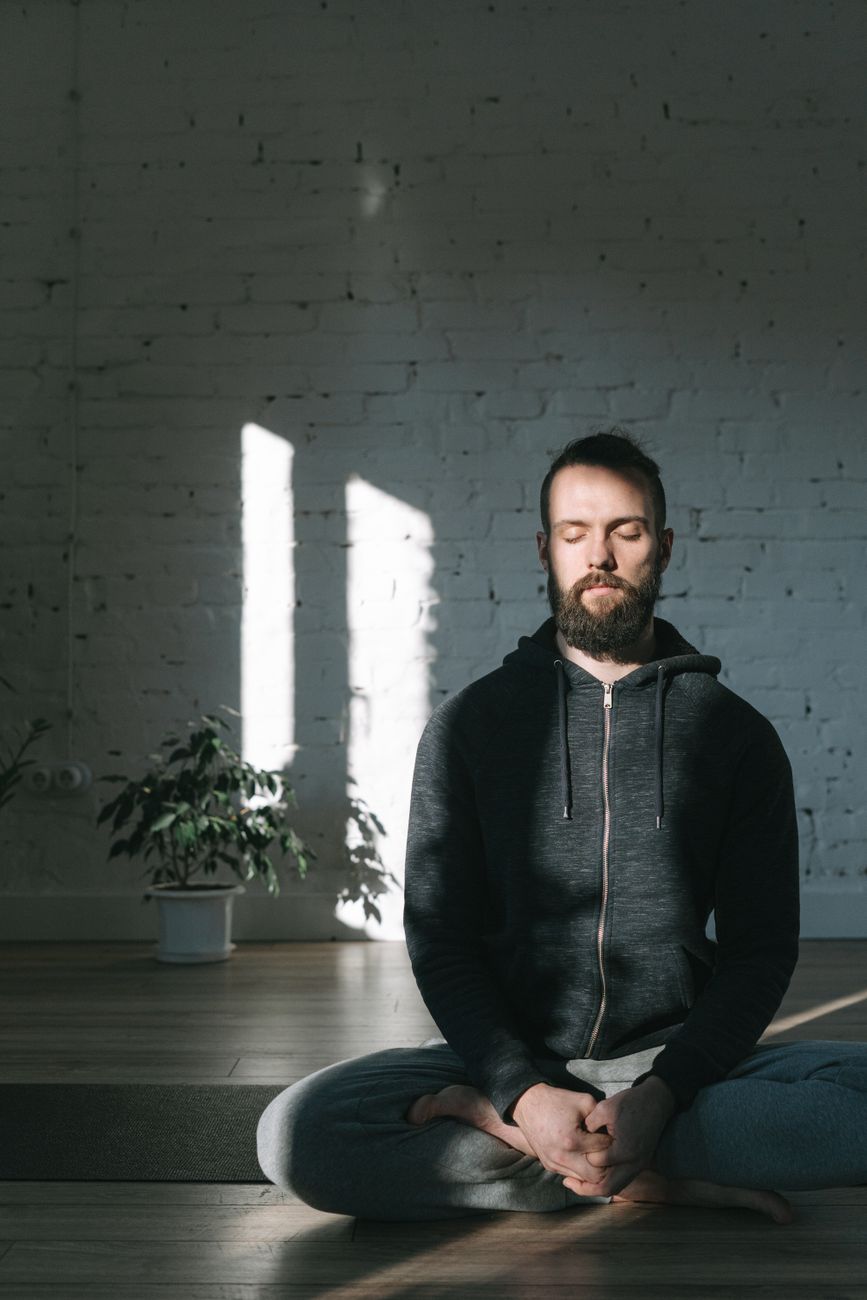 a man sitting in yoga mat meditating