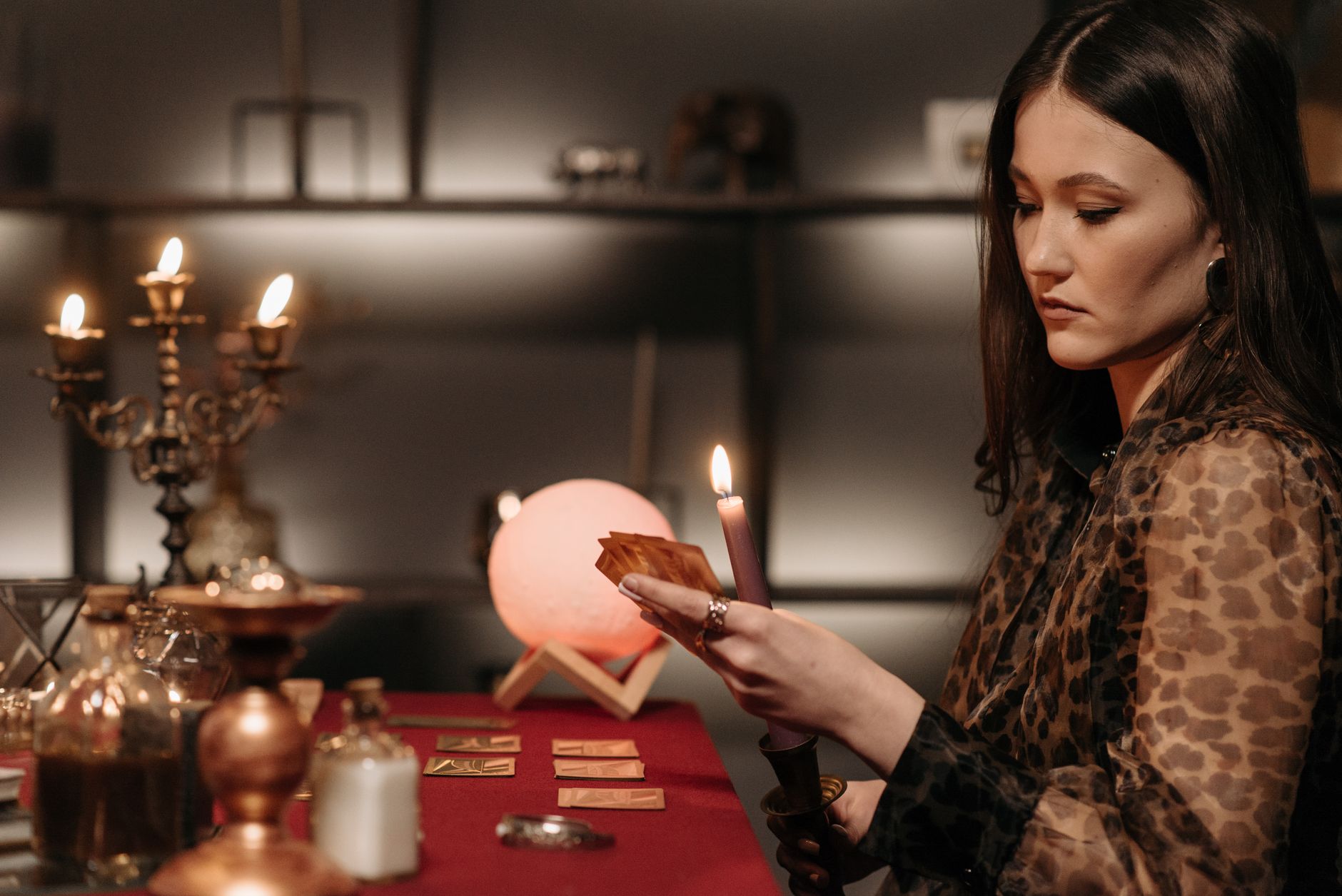 woman looking at the cards while holding a lighted candle